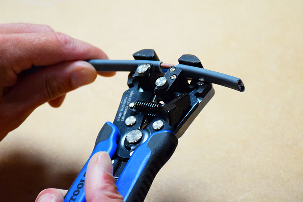 Self adjusting shop wire stripper